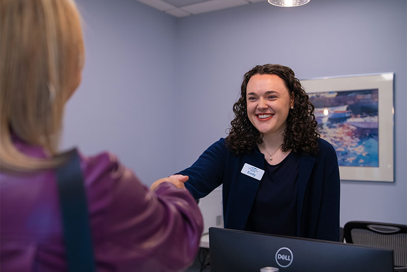 staff member helping patient at the front desk of the dental center