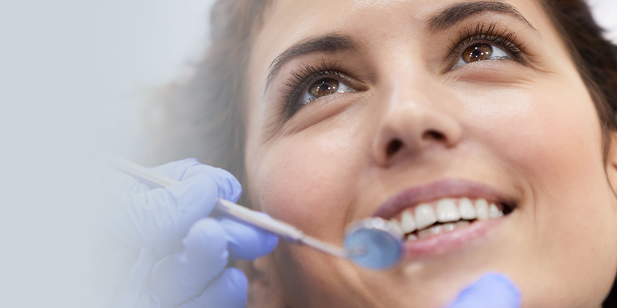 Closeup portrait of beautiful young woman lying in dental chair