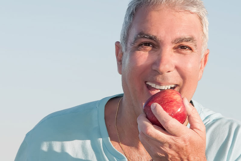 mature man biting into an apple