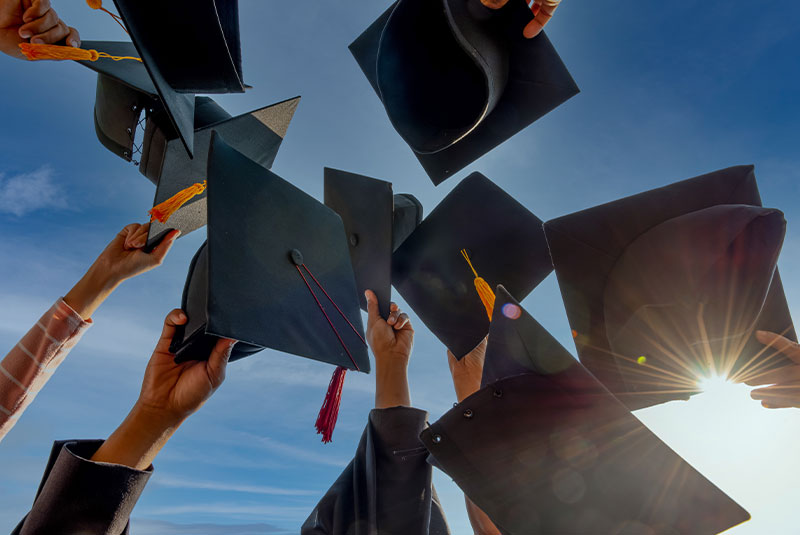 graduation cap being thrown in the air