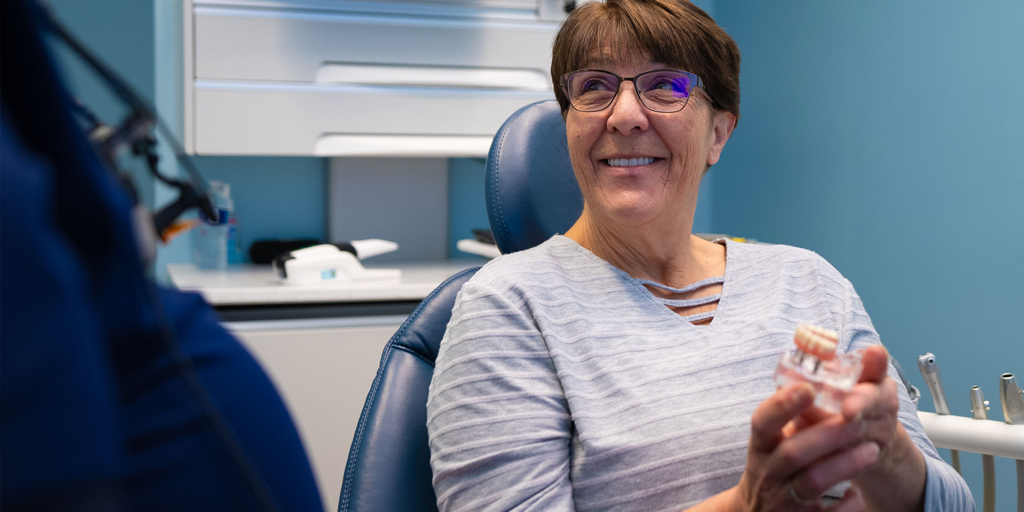 patient holding a full arch model implant