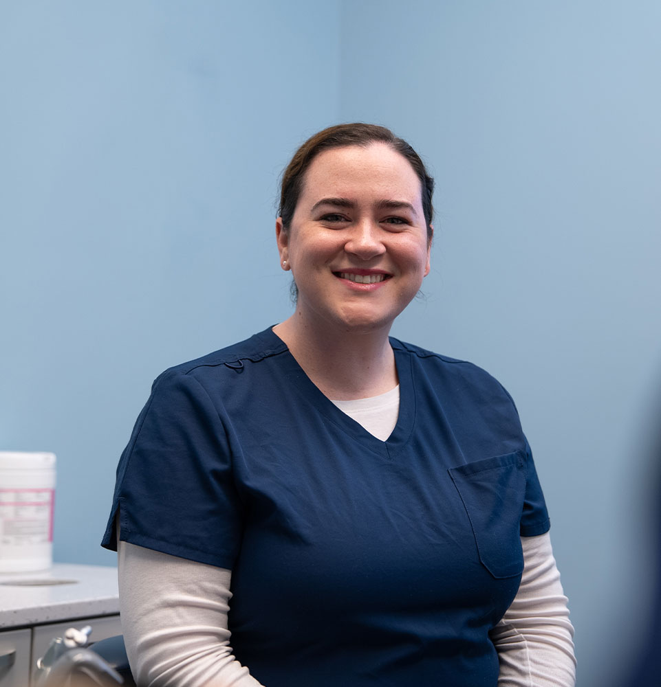 staff member helping and smiling dental patient within the dental center